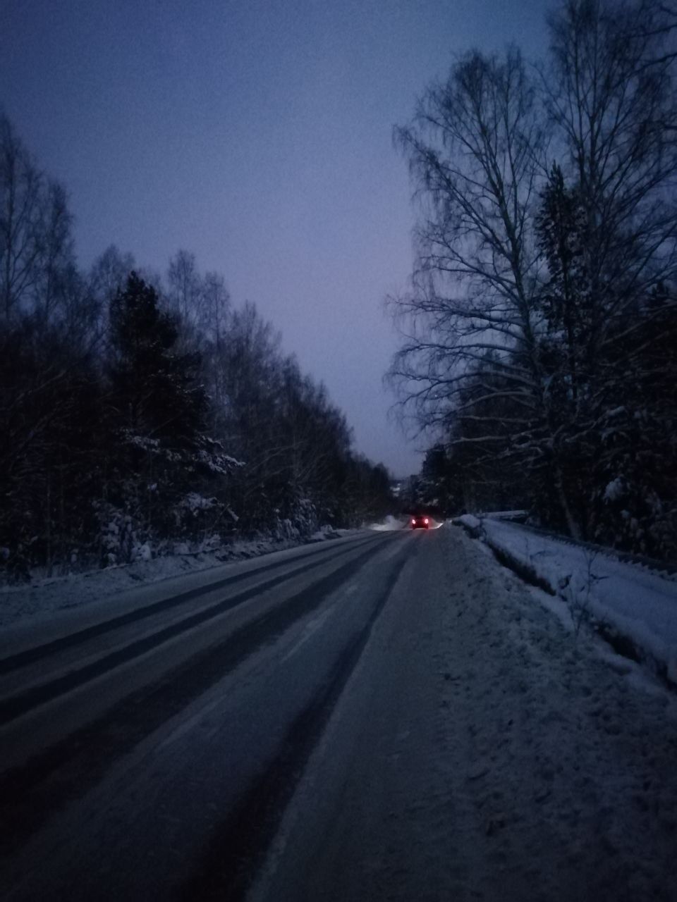 Winter Siberian road through the forest at dusk, near Novosibirsk